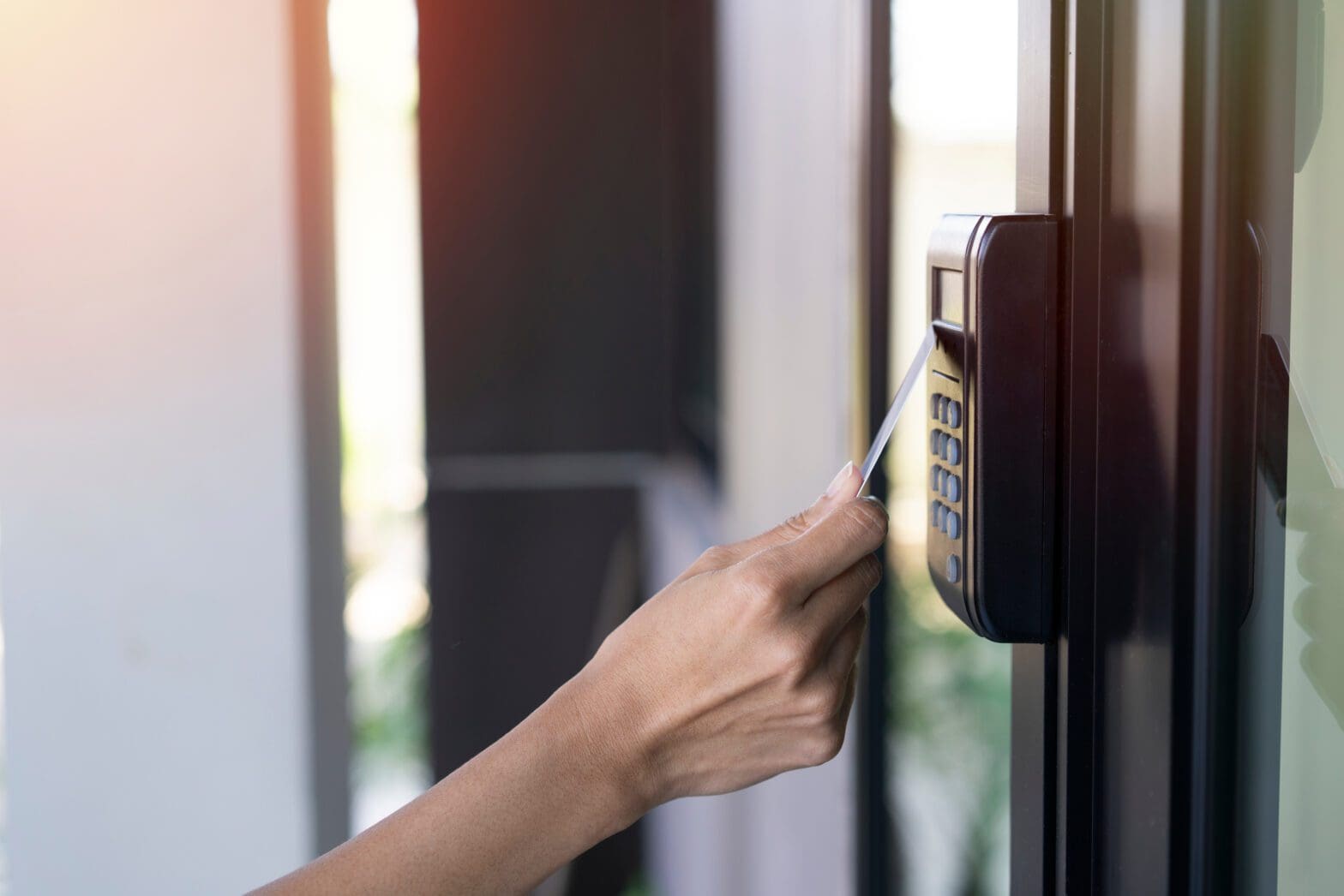 young woman using RFID tag key card, fingerprint and access control to open the door in a office building